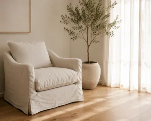 Serene minimalist living room ideas corner with a linen armchair and a single potted olive tree.