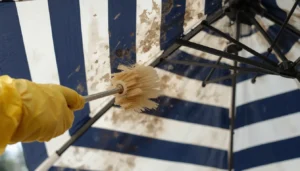 Scrubbing moldy outdoor umbrella fabric with an oxygen bleach solution and soft brush.