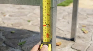 Measuring leg height on elevated raised garden beds for accessibility.