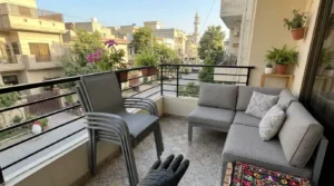 Stackable outdoor dining chairs fitted on a compact 6x6 balcony.
