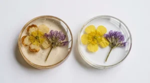 Two resin pendants, one browned and one clear, showing a casting mistake behind clear resin yellow flowers.