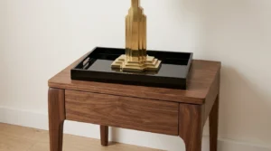 Lacquered tray on a walnut nightstand to mix art deco style with mid-century lines.